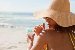 Woman applying sunscreen to her shoulder