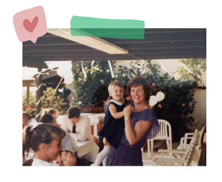 A mom holding her child and smiling for the camera