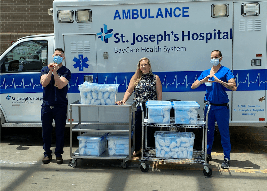 Prudence Millsap pictured with surgical masks and medical personnel in front of an ambulance