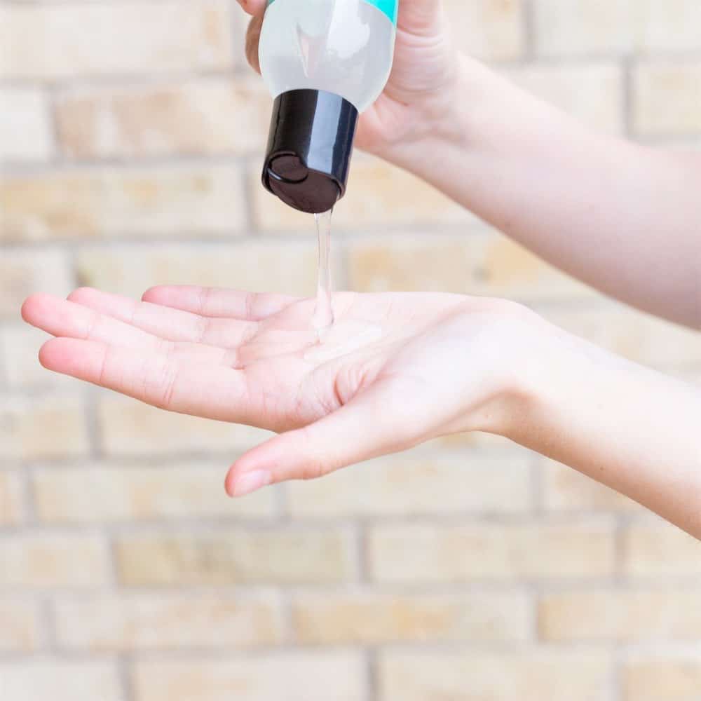 Woman pouring hand sanitizer into her hand.